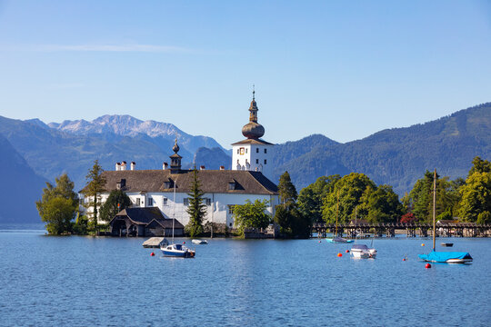 Boat sailing in Traunsee lake by Schloss Ort against sky, Gmunden, Salzkammergut, Upper Austria, Austria