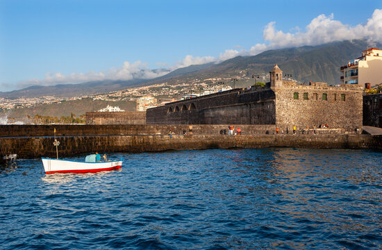 Spain, Canary Islands, Puerto de la Cruz, Boat floating in front of Bateria de Santa Barbara fort