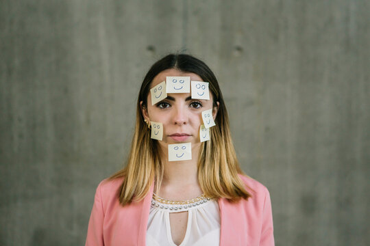 Portrait of serious woman wearing adhesive notes on face