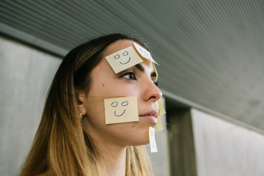 Portrait of serious woman wearing adhesive notes on face