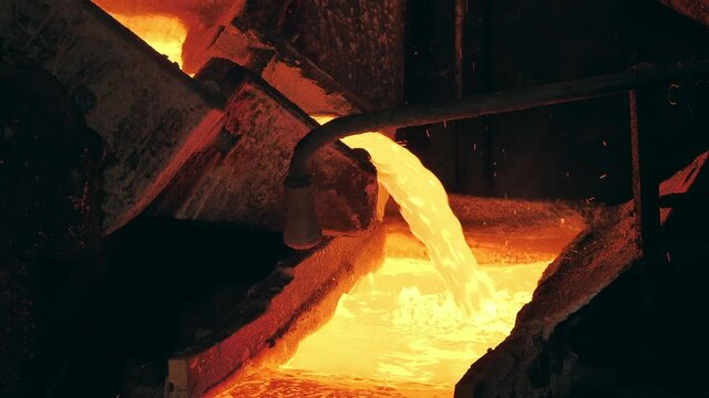 Foundry mechanism is pouring molten copper into a mold