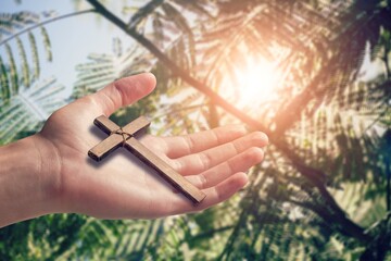 Christian human hands holding a cross holy and worship Pray to God with a natural background.
