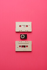 Música. Cassettes and music players. Music generations concept. New and old music. On a pink background.. Vertical