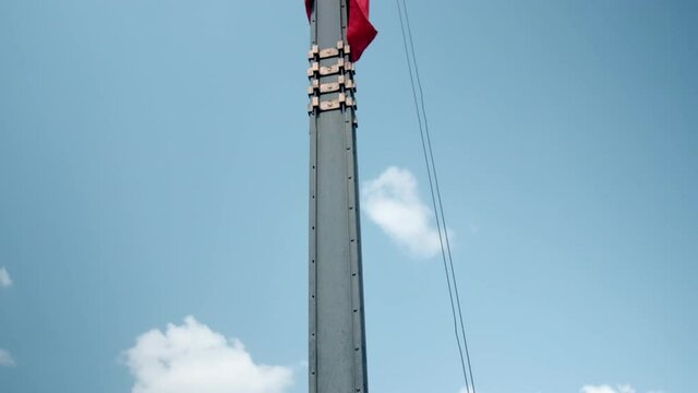 Mexican flag flying at half-mast under beautiful blue sky