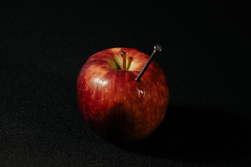 a red apple and nails on it