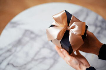 A gift in your hands. The concept of the new year and holidays. Designer gift boxes.