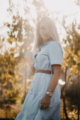 Vertical shot of a young Caucasian lady wearing a shirt-dress with a belt and accessories outdoors © Stefan Radosavljevic/Wirestock