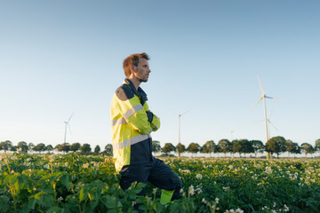 Engineer standing in a field at a wind farm