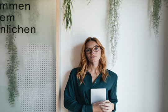 Portrait of serious businesswoman holding tablet