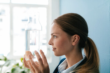 Young businesswoman holding carafe of fresh water