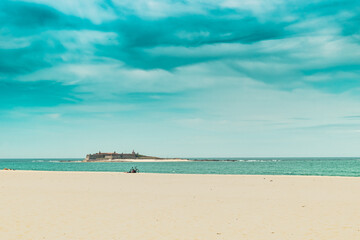Bike on the sand and small island with the Fort of Ínsua in the Atlantic Ocean with clouds in the sky, Caminha PORTUGAL
