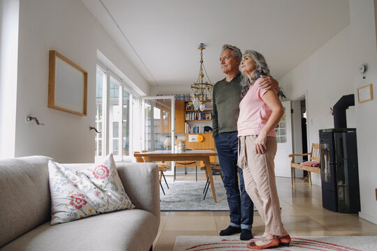 Senior couple standing in living room at home