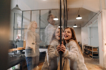 Businessman and businesswoman with mischievous girl in office