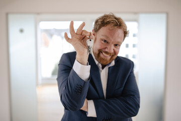 Portrait of smiling businessman holding key