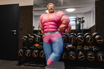 Proud man wearing pink bodybuilder costume in gym