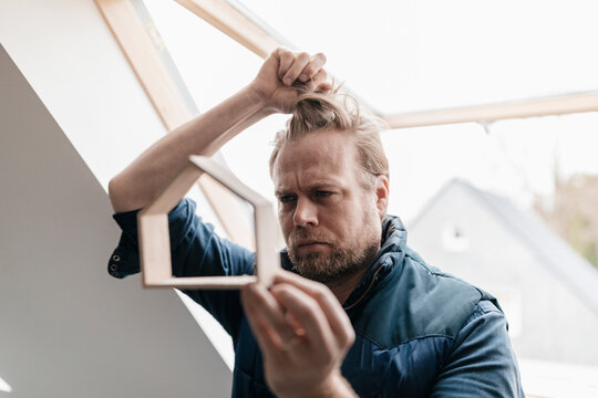 Architect looking through wooden house model