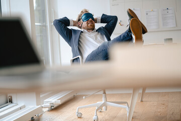 Businessman having a power nap at desk in office