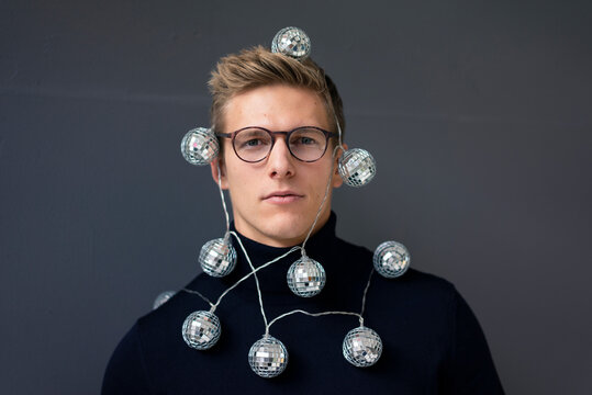 Portrait of young man wearing mirror ball fairy lights