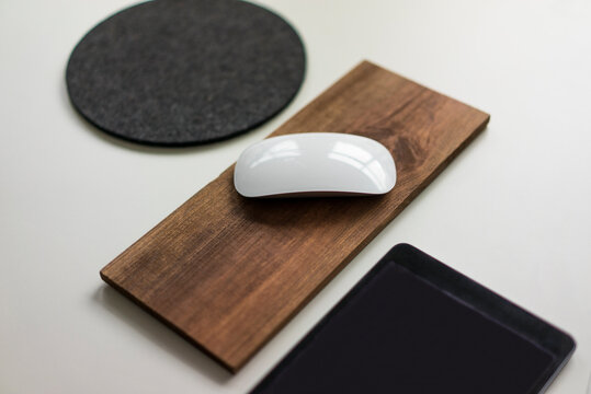 Computer mouse on wooden board on a desk