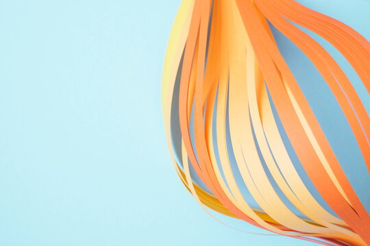 Close-up of orange quilling papers on blue background
