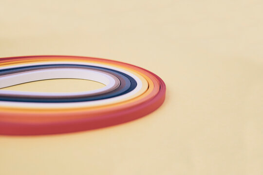 Close-up of multi colored quilling papers on beige background