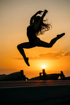 Silhouette of ballerina daning at sunset