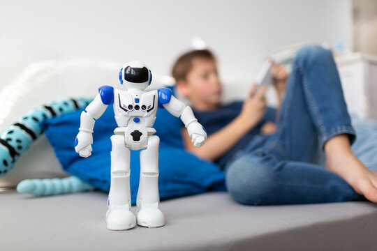 Little robot standing in front of a boy in his room