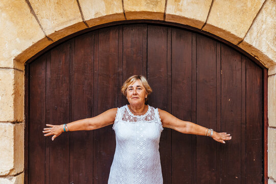 Portrait of a senior woman in front of a wooden door