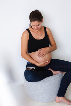 Young pregnant woman with ultrasound image of her unborn baby