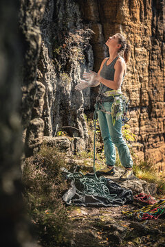 Woman preparing to climb, looking up on climbing wall