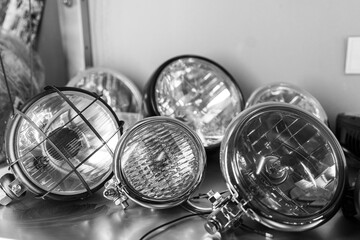 Close-up of various motorcycle headlights lying on shelf