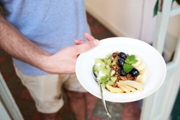 Close-up of man holding plate with healthy breakfast