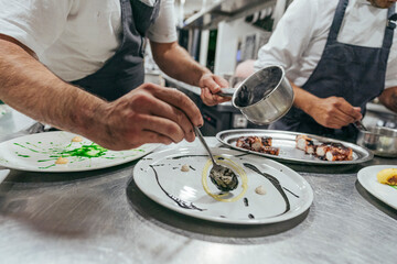 Chef garnishing plate with food