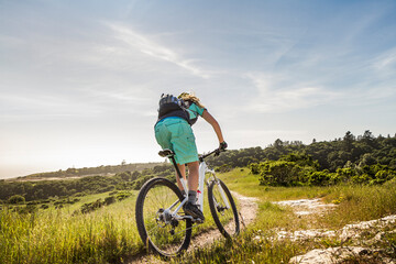 Female mountainbiker riding down narrow trail, Santa Cruz, California, USA