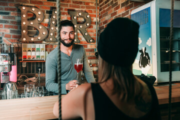 Barkeeper serving woman a cocktail