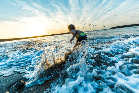 Boy playing at the seafront during sunset, Adeje, Tenerife, Canarian Islands, Spain
