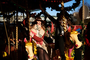 Two happy women having fun on a carousel