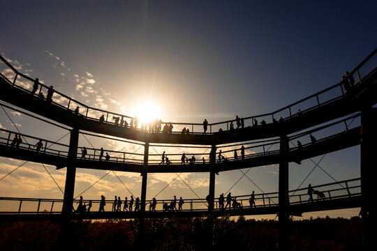 Germany, Bavaria, Ebrach, Silhouettes of people at Baumwipfelpfad walkway at sunset