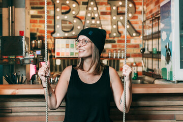 Smiling woman sitting on a swing in a hotel bar