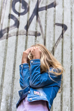 Blond girl hiding her face