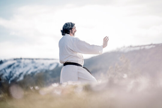Senior man practicing karate outdoors