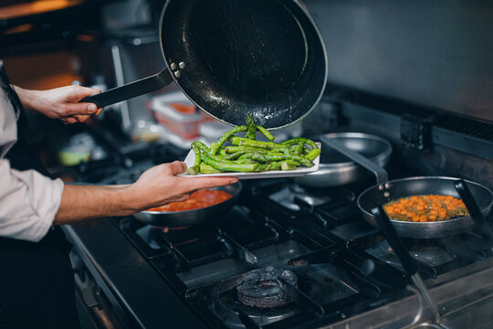 Chef Preparing Green Asparagus Dish In Restaurant Kitchen