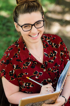 Portrait of laughing woman writing in notebook