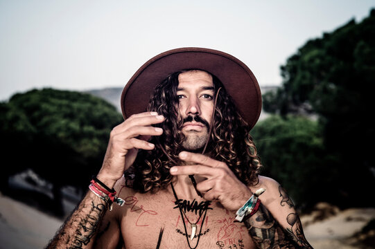Young man with hat, tattoos and mustache