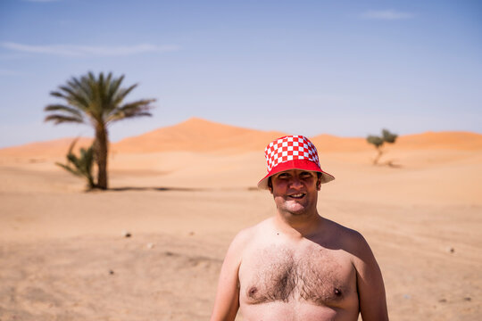 Portrait of barechested overweight man in the desert of Morocco