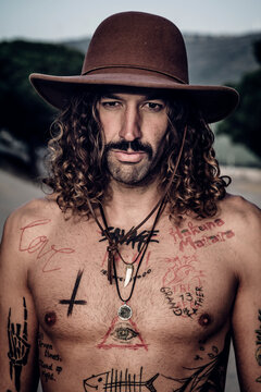 Young man with hat, tattoos and mustache