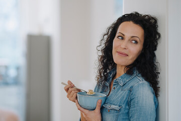 Beautiful woman having healthy breakfast, eating granola