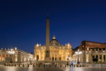 Illuminated St. Peter's Square with obelisk and St. Peter's Basilica against clear blue sky at night, Vatican City, Rome, Italy