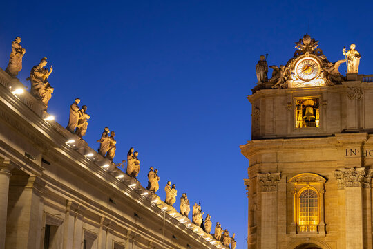 Illuminated saint statues on St. Peter's Basilica against clear blue sky at night, Vatican City, Rome, Italy