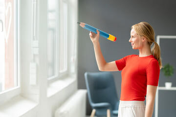 Young woman in office with oversized pen